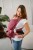 Modelka nosi dziecko w ergonomicznego nosidle KAVKA handy burgundy braid cotton - burgundowe nosidło z białym wzorem warkocza (burgundy carrier with a white braid pattern)